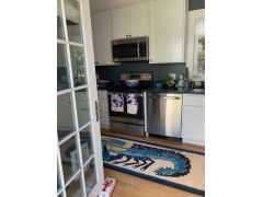 Kitchen opens onto yard with patio and lovely plantings 